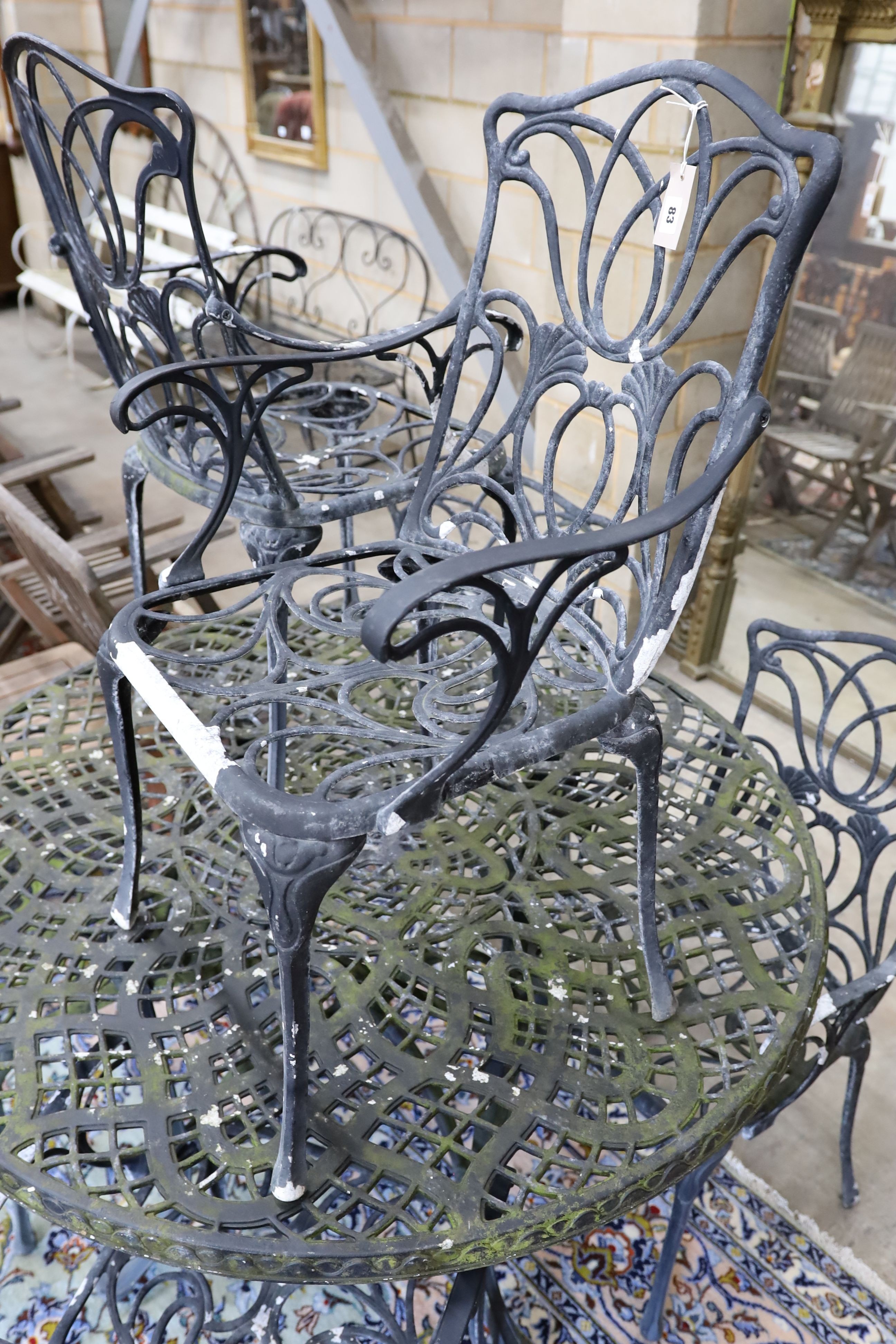 A painted aluminium circular garden table, diameter 124cm, height 73cm and six aluminium garden elbow chairs